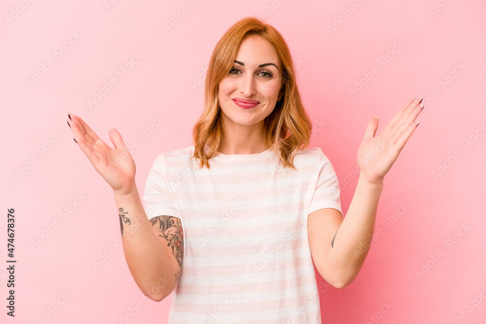 Young caucasian woman isolated on pink background holding something little with forefingers, smiling and confident. Young caucasian woman isolated on pink background holding something little with forefingers, smiling and confident.