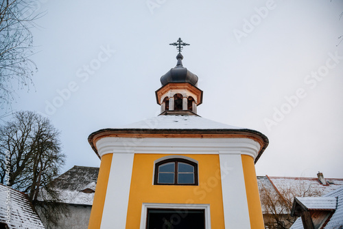 Prerov nad Labem, Czech Republic, 5 December 2021: Traditional village wooden house in winter, historic country-style architecture, Municipal Belfry small church, Polabi open-air ethnographic museum photo