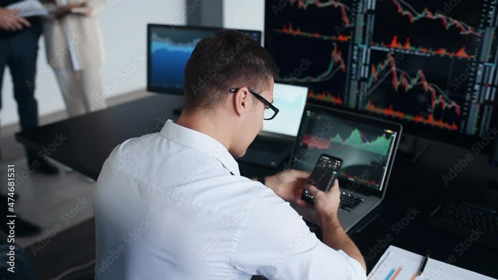 Team of stockbrokers works together in modern office at daytime Team of stockbrokers works together in modern office at daytime