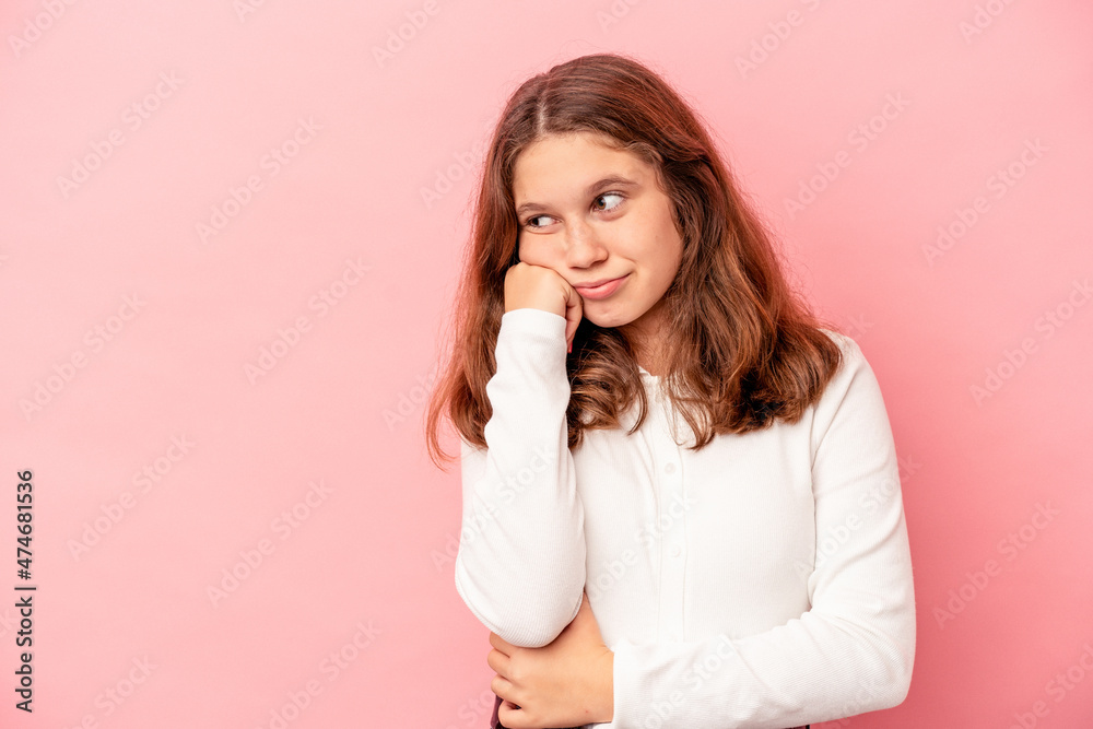 Fototapeta premium Little caucasian girl isolated on pink background who feels sad and pensive, looking at copy space.