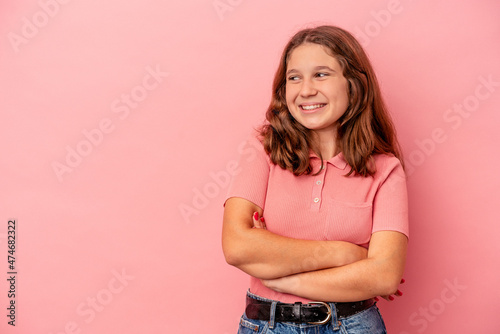 Little caucasian girl isolated on pink background smiling confident with crossed arms.