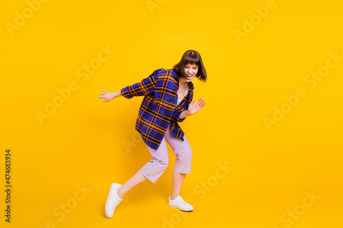 Full length body size view of attractive cheerful funky girl dancing having fun rest chill isolated over bright yellow color background
