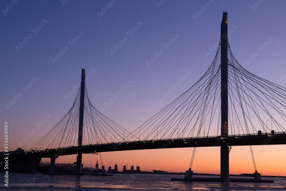 Obraz premium Large suspension bridge over the Neva River and the Bay in St. Petersburg, Russia, at sunset