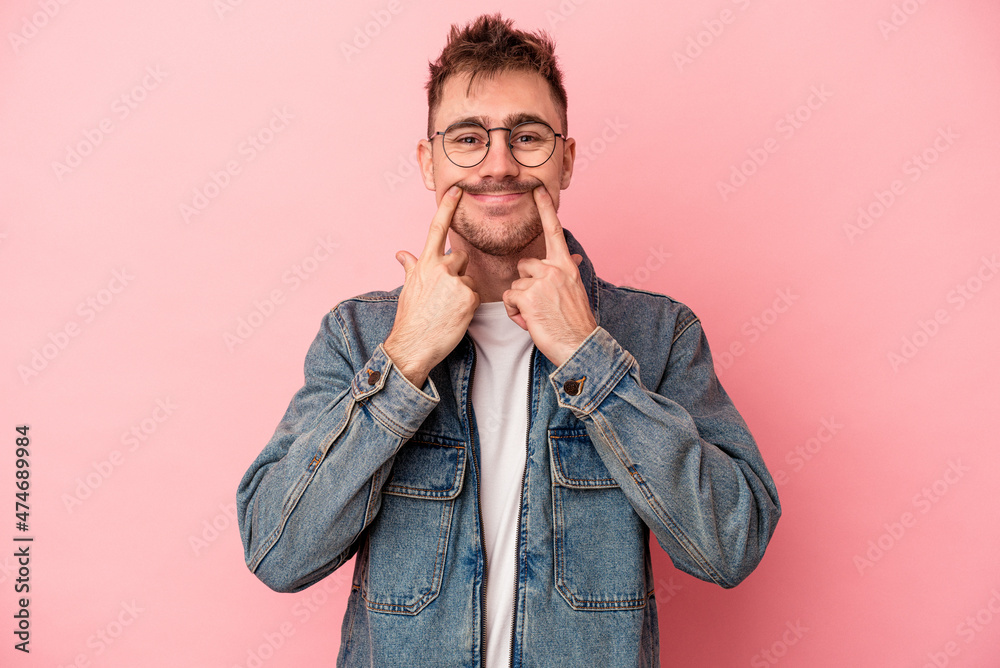 Young caucasian man isolated on pink background doubting between two options. Young caucasian man isolated on pink background doubting between two options.