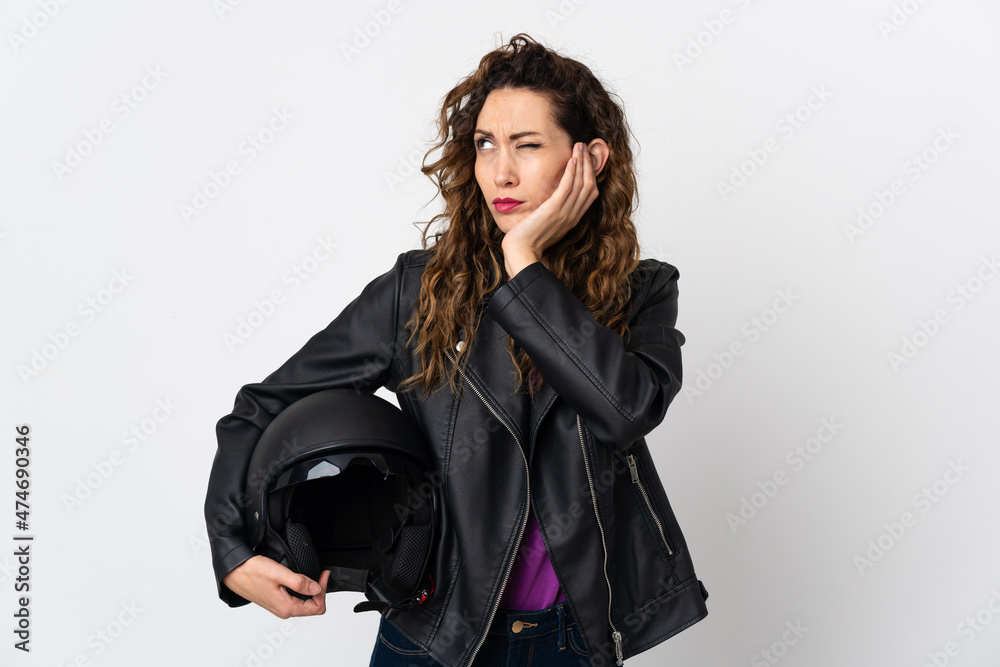 Young caucasian woman holding a motorcycle helmet frustrated and covering ears Young caucasian woman holding a motorcycle helmet frustrated and covering ears