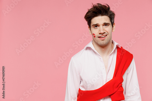 Foto Young confused caucasian man 20s with lipstick lips on face cheek wearing casual shirt sweater look camera isolated on pink background studio