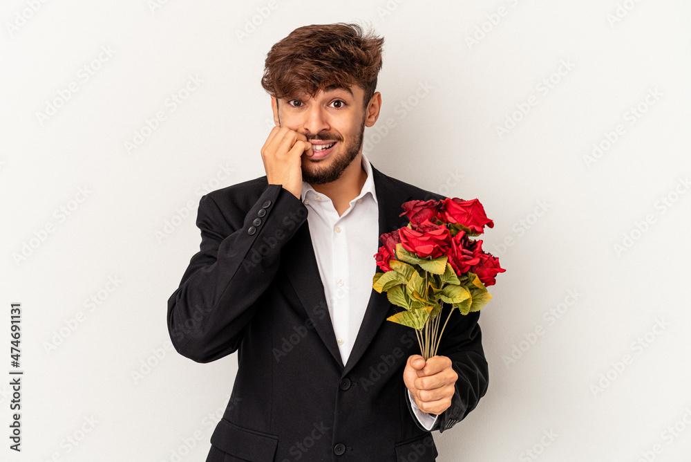 Young mixed race man holding bouquet of roses isolated on white background biting fingernails, nervous and very anxious. Young mixed race man holding bouquet of roses isolated on white background biting fingernails, nervous and very anxious.