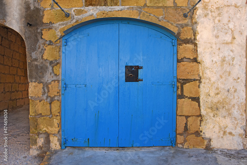 old wooden blue double garage door in a wall