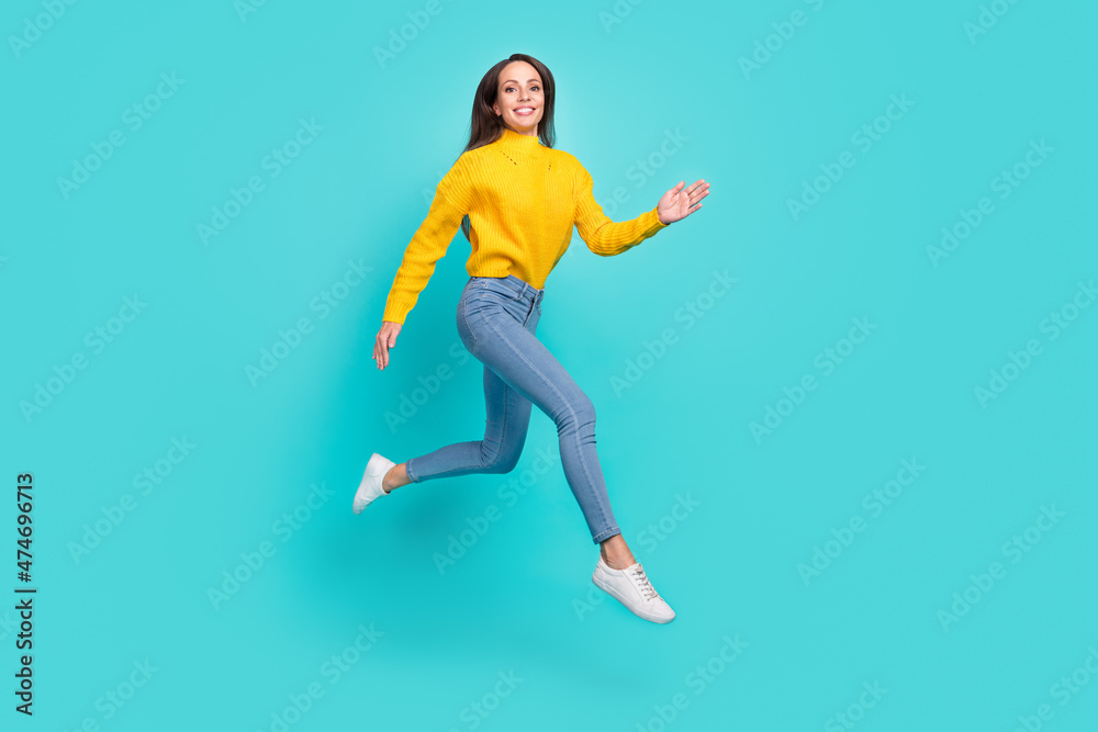 Full length body size view of attractive cheerful thin girl jumping running isolated over vivid teal turquoise color background Full length body size view of attractive cheerful thin girl jumping running isolated over vivid teal turquoise color background