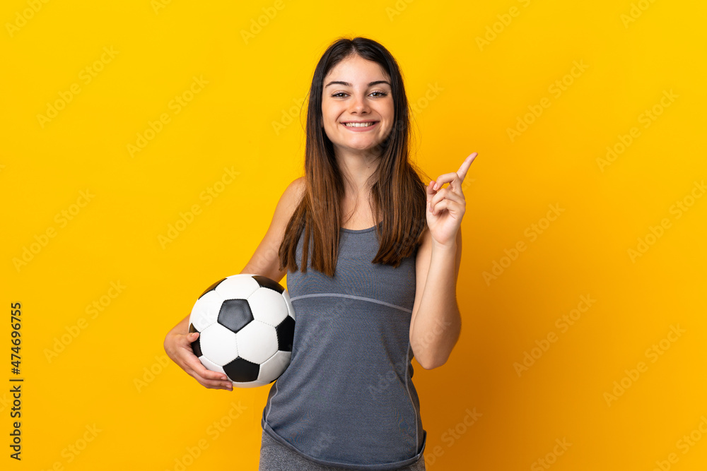 Young football player woman isolated on yellow background showing and lifting a finger in sign of the best Young football player woman isolated on yellow background showing and lifting a finger in sign of the best