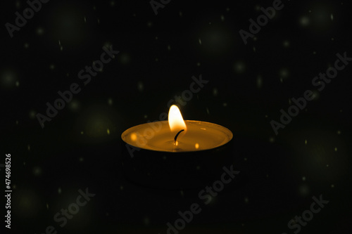 Burning wax candle on a black background 