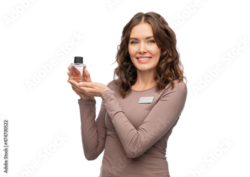 sale, shopping and perfumery concept - happy female shop assistant with perfume over white background