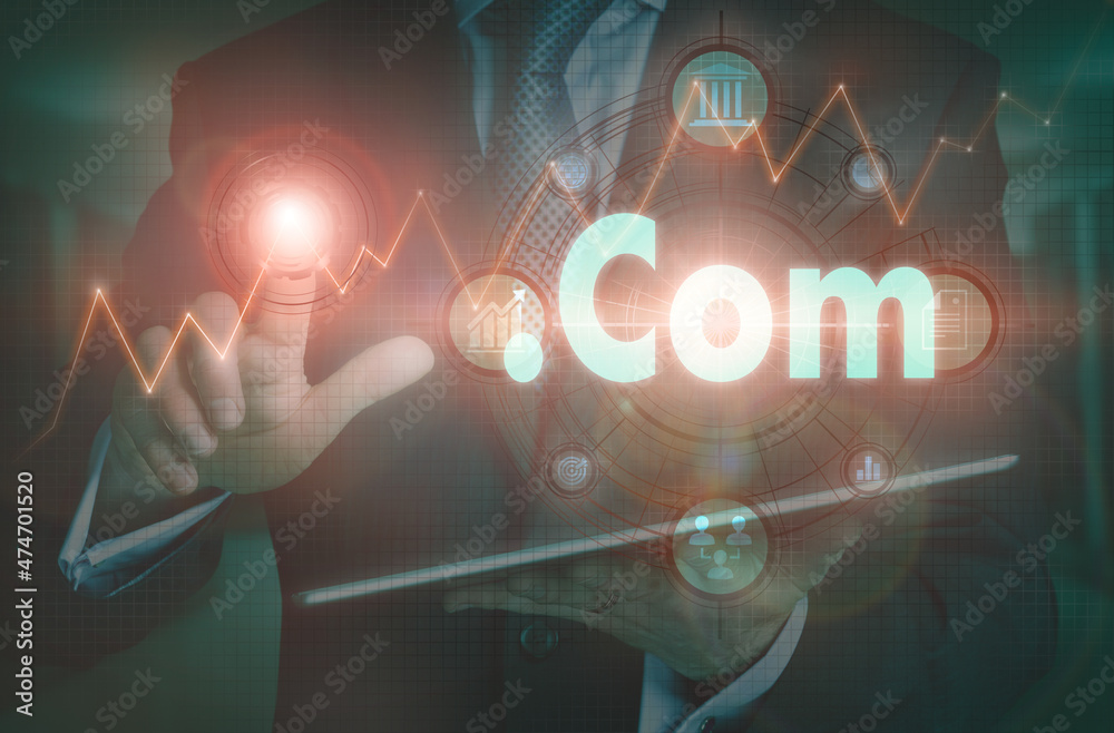A businessman operating a computer display with a Dot Com business word concept on it.