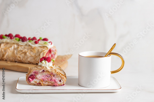 Meringue roll cake with berries whipped cream and coffe on marble background. Copy space.