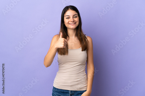 Young caucasian woman isolated on purple background giving a thumbs up gesture
