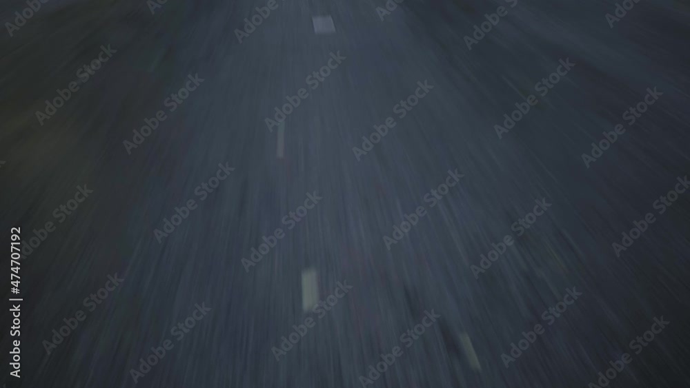 close-up cinematic POV shot of an wet asphalt road. Car is driving on the highway 