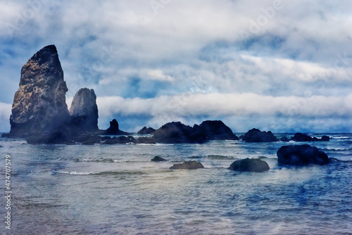 A crisp morning sunrise merges with the rocks and waves of Cannon Beach on the coast of Oregon.