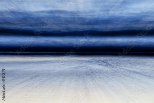 Photography Surging waves and grey steely skies spill onto the beach during the twilight hours