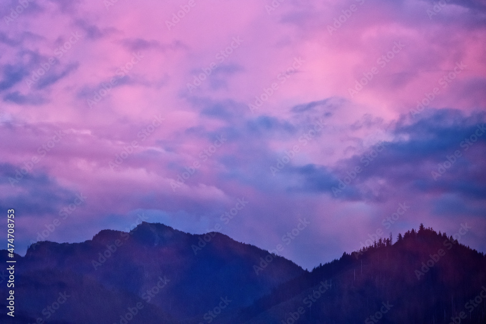 Mountains rise into the purple cloudy skies of twilight. Mountains rise into the purple cloudy skies of twilight.