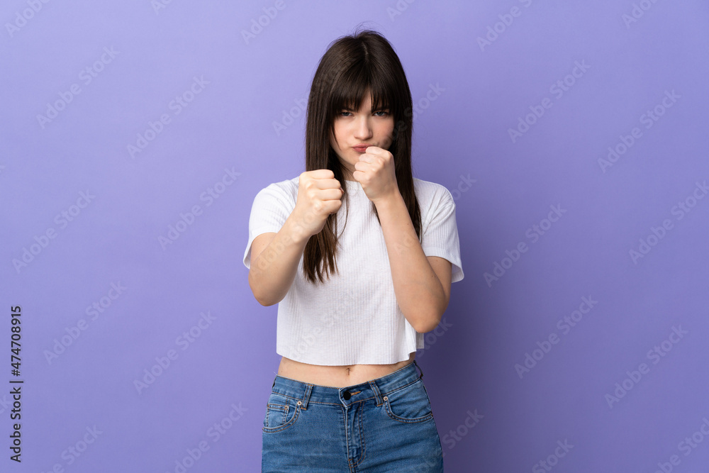Young Ukrainian woman isolated on purple background with fighting gesture Young Ukrainian woman isolated on purple background with fighting gesture