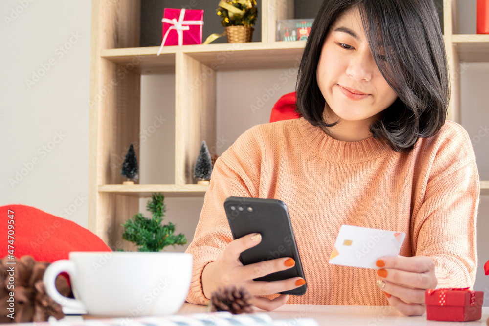 young asian woman using mobile phone and holding credit card for christmas online shopping young asian woman using mobile phone and holding credit card for christmas online shopping