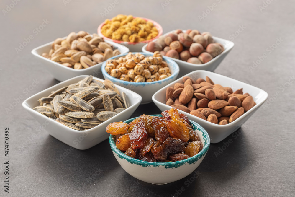 Seedless grapes in selective focus . Dried mulberry, hazelnut, pistachio, yellow chickpea, pistachio, almond and sunflower seeds in the background. Seedless grapes in selective focus . Dried mulberry, hazelnut, pistachio, yellow chickpea, pistachio, almond and sunflower seeds in the background.