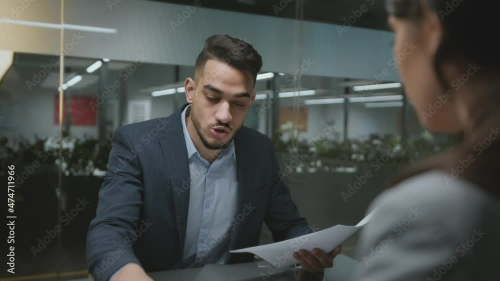 Sexism at workplace. Young angry middle eastern foreman shouting at upset woman employee at office, tracking shot Sexism at workplace. Young angry middle eastern foreman shouting at upset woman employee at office, tracking shot