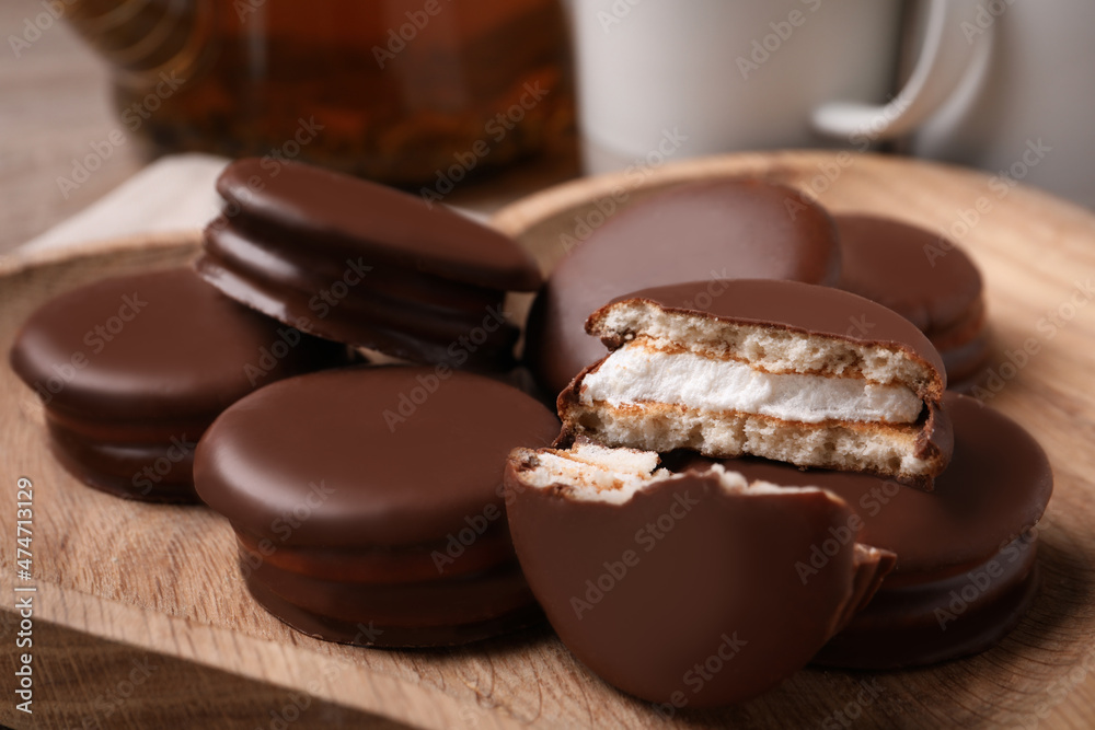 Tasty choco pies on wooden plate, closeup view Tasty choco pies on wooden plate, closeup view