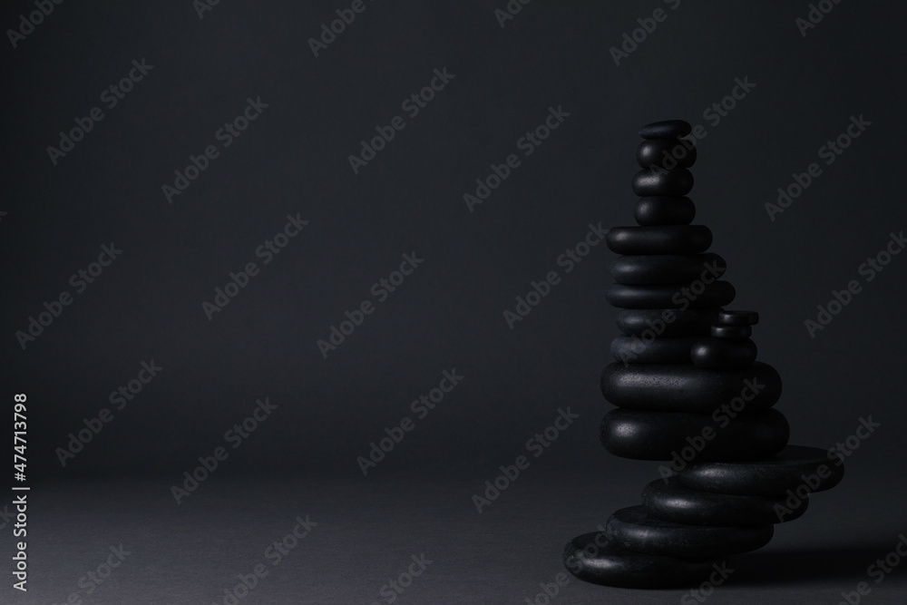 Stack of stones on black background, space for text. Harmony and balance concept Stack of stones on black background, space for text. Harmony and balance concept