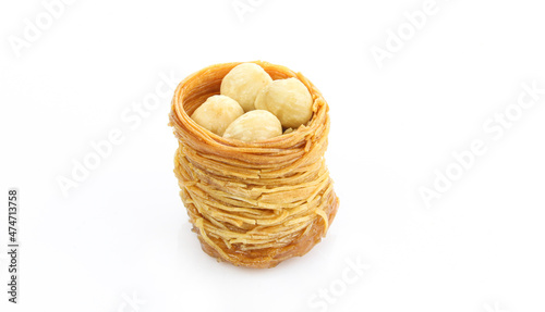 Hazelnuts in kadayif shaped like bird nest. Turkish delicacy isolated on white background