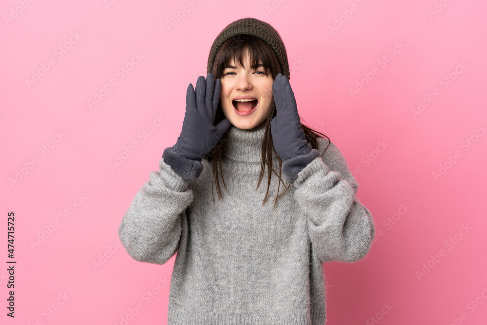 Teenager Ukrainian girl with winter hat isolated on white background shouting with mouth wide open Teenager Ukrainian girl with winter hat isolated on white background shouting with mouth wide open