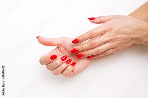 Close-up of a woman's hands with a perfect professional bright red manicure on a white background. Red Nail polish