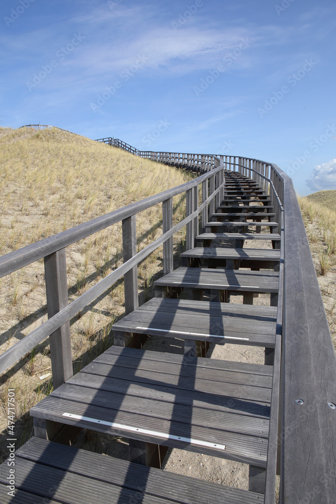 A wooden stairway in the dunes of Petten, the Netherlands, leading to a viewing point
