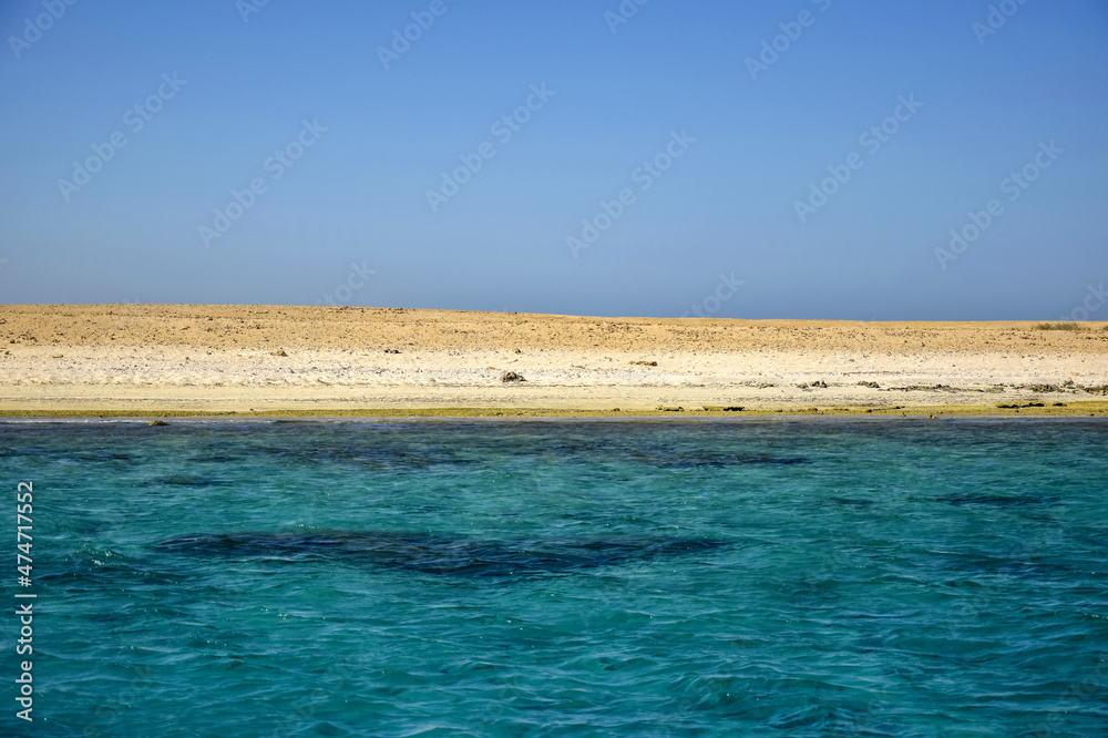 Scenic view of deserted seaside with sandy beach against backdrop of blue sky. Beautiful seascape. Copy space. Selective focus. Scenic view of deserted seaside with sandy beach against backdrop of blue sky. Beautiful seascape. Copy space. Selective focus.
