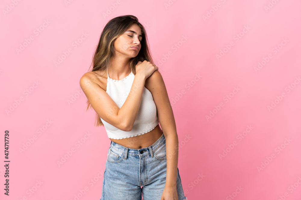 Young caucasian woman isolated on pink background suffering from pain in shoulder for having made an effort Young caucasian woman isolated on pink background suffering from pain in shoulder for having made an effort
