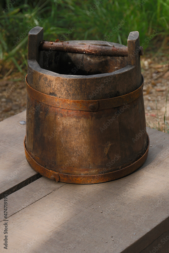 An old wooden bucket used to get water out of a well
