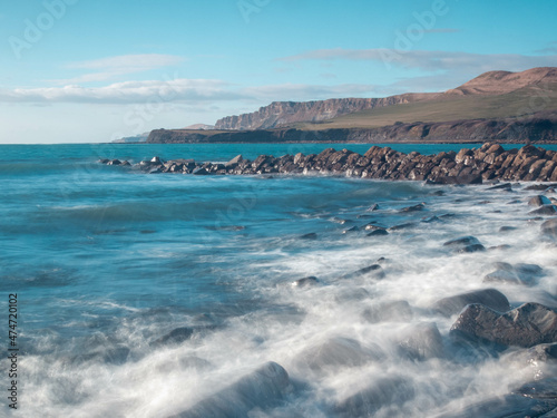 blurred water movement waves over the rocks at Clavells Pier Jurassic Coastline Kimmeridge Dorset England photo