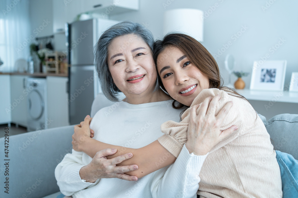 Portrait of Asian lovely family, young daughter hugging older mother. 