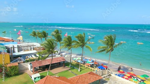 Beautiful brazilian beach, some coconut trees and blue sea. Aerial view of Porto de Galinhas beach, tourist destination of the brazilian northeast. Zoom out video.