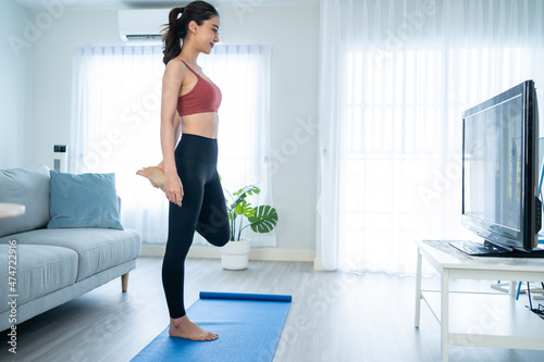 Asian young beautiful active woman doing Yoga Pilates workout at home.