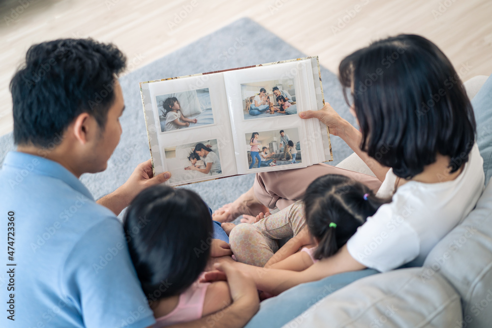 Obraz premium Asian family look at photographs on old picture album recalls the past