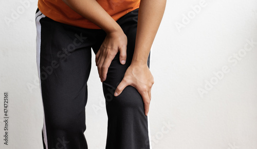 Woman hand massage physiotherapy her knee is sore and numb, exhausted, tingling. Guillain-Barre Syndrome, a side effect of the Covid vaccination photo