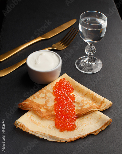 Golden russian pancakes with red caviar. Traditional Maslenitsa food. Christmas and New Year celebration. photo