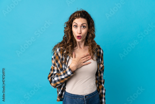 Young caucasian woman isolated on blue background surprised and shocked while looking right © luismolinero