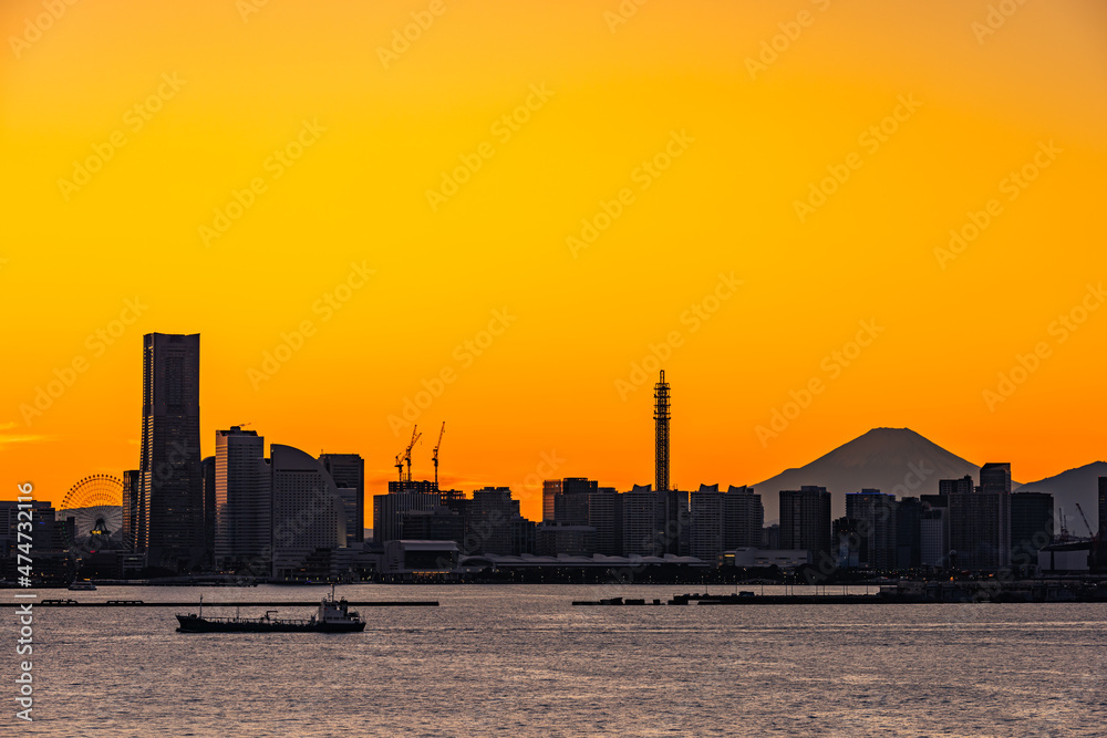 夕日に染まる横浜港と富士山のシルエット