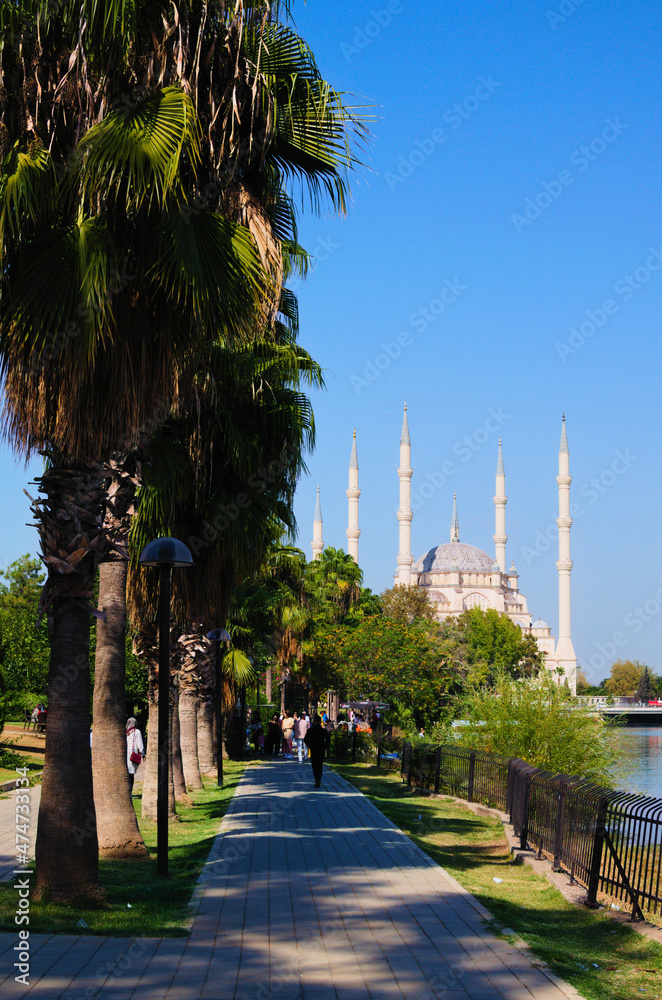 Adana, Turkey-October 10, 2021:Beautiful landscape photo of Sabanci Central Mosque (Turkish: Sabanci Merkez Cami). Tree leaves border. Natural frame. Travel and tourism concept