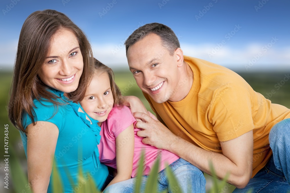 happy family with children having good time sitting on the grass in city park happy family with children having good time sitting on the grass in city park