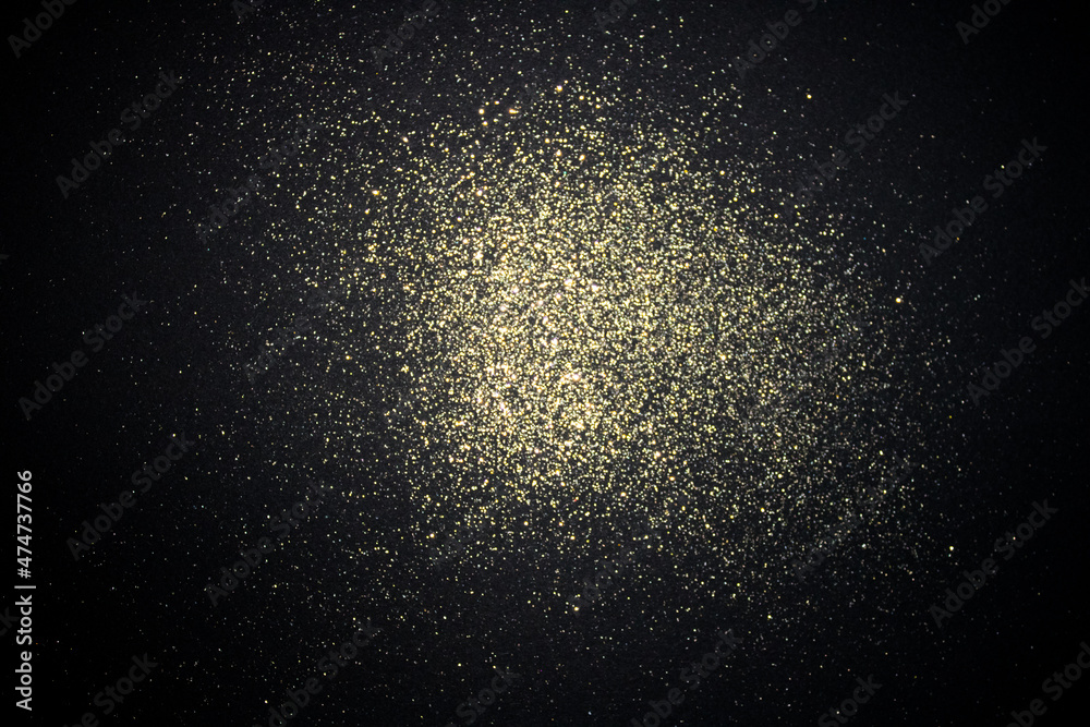 Fototapeta premium Old gold glitter on black background. Simple festive layout.