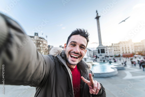 Fototapeta Smiling man taking selfie portrait during travel in London, England - Young tour