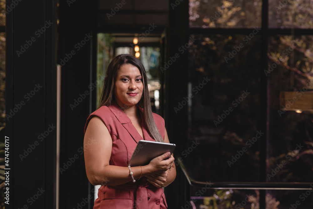 Hermosa mujer latina de negocios con una tableta digital en sus manos	
 - obrazy, fototapety, plakaty 